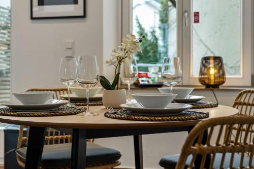 a wooden table with glasses and plates on it at APARTVIEW Apartments Krefeld - WLAN - Zentral - ruhig in Krefeld