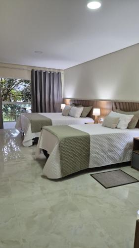 two beds in a large room with at Pousada Recanto Família in Paraty