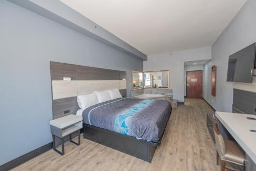 Habitación de hotel con cama y escritorio en Jamestown inn & Suites, en Riverdale