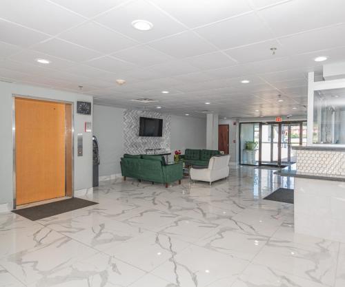 a living room with a green couch and a television at Jamestown inn & Suites in Riverdale