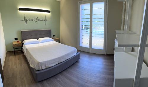 a bedroom with a bed and a large window at AL CASCINALE PESCHIERA DEL GARDA in Peschiera del Garda