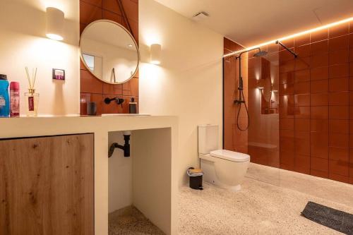 a bathroom with a toilet and a sink and a mirror at Suite de lujo estilo mediterráneo in Valencia