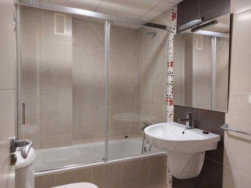 a bathroom with a shower and a sink and a toilet at Misterhost Triana Remedios 2BR & parking in Seville