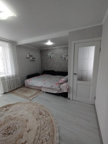 sypialnia z łóżkiem, drzwiami i dywanem w obiekcie Balti Apartment w mieście Bielce
