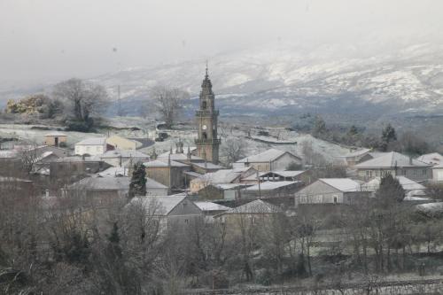 a town with a clock tower and snow covered roofs at “Casa abella “ in La Magdalena