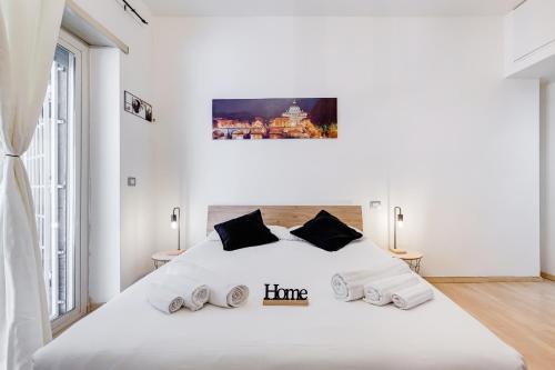 a white bedroom with a large white bed with two lamps at Aventino Industrial Loft in Rome