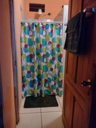 a shower with a colorful shower curtain in a bathroom at Tessa's Inn in Arima