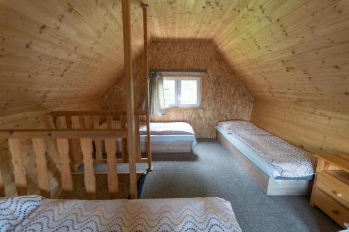 a bedroom with two beds in a wooden cabin at Chaty - Resort AQUA MARIA in Veľaty