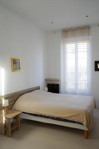 - une chambre avec un grand lit et une fenêtre dans l'établissement Appartement Nice le Port, à Nice
