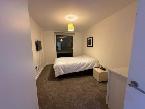 - une chambre avec un lit blanc et une fenêtre dans l'établissement 3 bed apartment near CanaryWharf, à Londres
