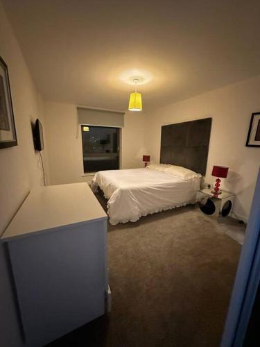 - une chambre avec un lit blanc et une fenêtre dans l'établissement 3 bed apartment near CanaryWharf, à Londres