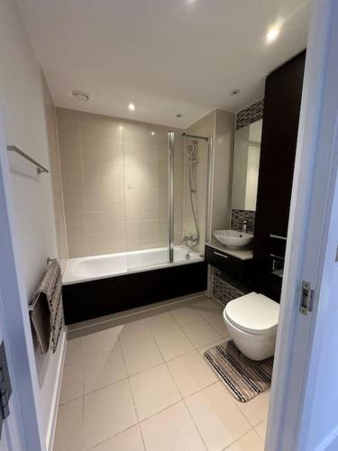 La salle de bains est pourvue d'une baignoire, de toilettes et d'un lavabo. dans l'établissement 3 bed apartment near CanaryWharf, à Londres