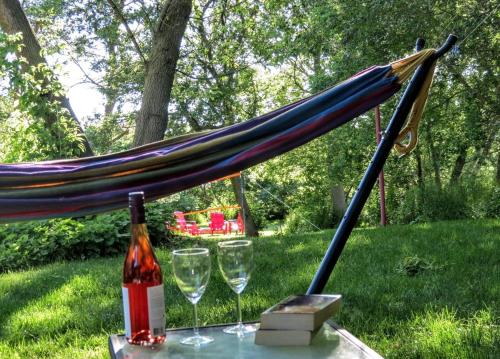 a hammock with two glasses and a bottle of wine at County Escape on Corey in Bloomfield
