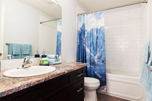 a bathroom with a sink and a toilet and a shower at Modern Home - King Bed - Garage - Long Stays in Edmonton