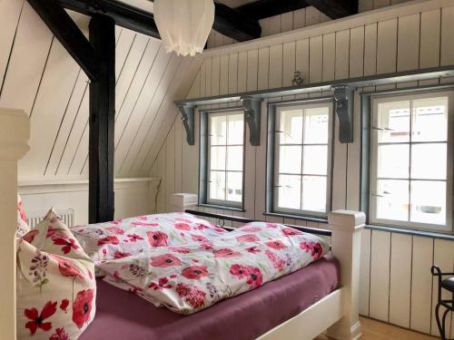a bedroom with a bed and two windows at First Class Ferienwohnung mit Sauna, Bar u. Wirlpool in Steinhude in Steinhude