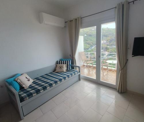 a bedroom with a bed and a sliding glass door at Enjoy sunset from a wonderful traditional studio-Melina in Ioulis