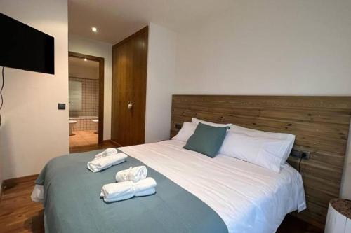a bedroom with a large bed with towels on it at Fantástico apartamento con vistas a Llivia in Llivia