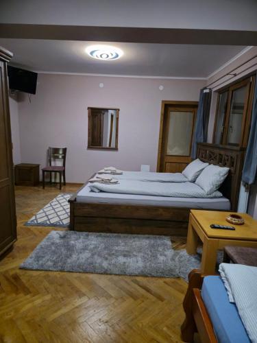 um quarto com uma cama grande e um sofá em Комитите em Troyan