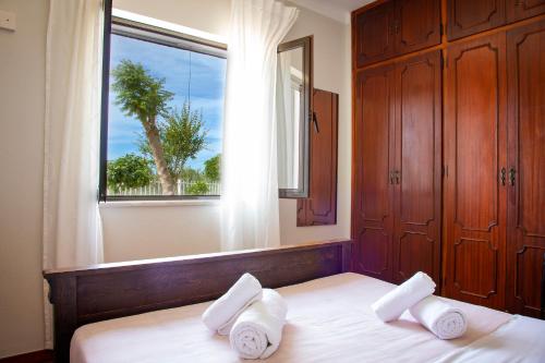 um quarto com uma cama com duas almofadas e uma janela em 4Ever Palace - Design & Nature em Alcácer do Sal