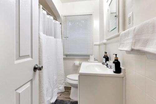 Comfy Home Near Downtown Detroit في ديترويت: حمام ابيض مع مرحاض ومغسلة