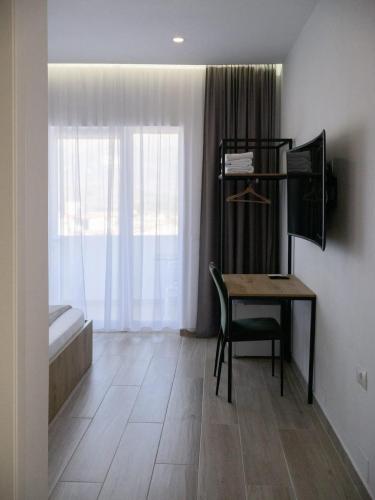 a room with a desk and a chair and a window at Patio Rooms Gjirokaster in Gjirokastër