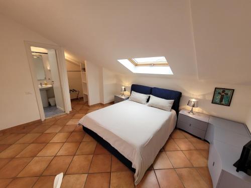 a bedroom with a large white bed and a skylight at Le Terrazze in Tropea