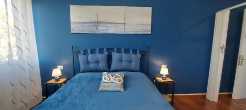 a blue bedroom with a blue bed with two lamps at Seaview Beach Front Grado Pineta Andromeda in Grado-Pineta