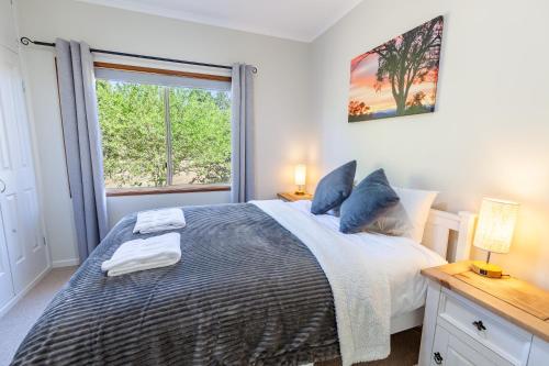a bedroom with a large bed and a window at Lazy K - Hideaway in Kalkite