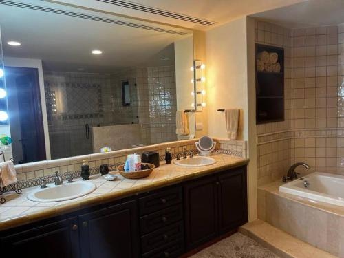 a bathroom with two sinks and a large mirror at Hermoso y Exclusivo Departamento in Cabo San Lucas