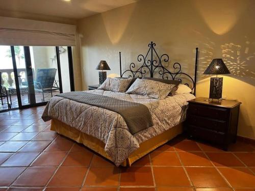 a bedroom with a bed and a table with two lamps at Hermoso y Exclusivo Departamento in Cabo San Lucas