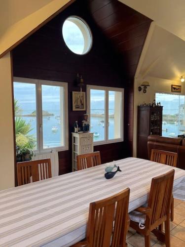 d'une salle à manger avec une grande table, des chaises et des fenêtres. dans l'établissement Chez Mado et Marcel, à Ploubazlanec