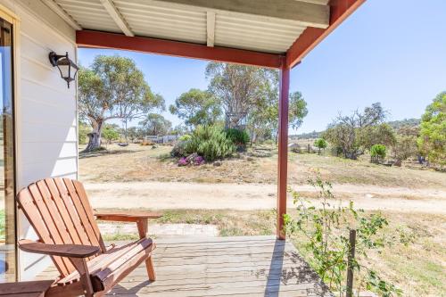 a rocking chair on a porch with a view of a field at Lazy K - Hideaway in Kalkite