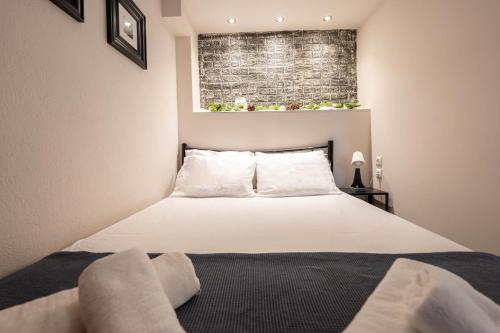 1 dormitorio con 1 cama blanca grande y ventana en Studio Ocean, en Paralia Dionisiou