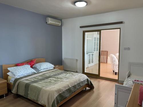sypialnia z łóżkiem i przesuwnymi szklanymi drzwiami w obiekcie Horizon 2 Cozy Villa w mieście Amman