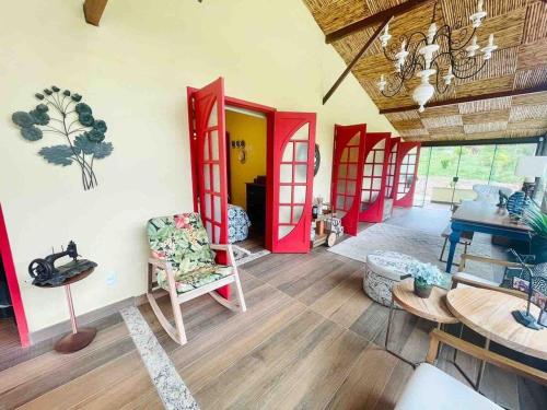- un salon avec des portes rouges et du parquet dans l'établissement Sítio incrível com piscina e lago, à Nova Friburgo