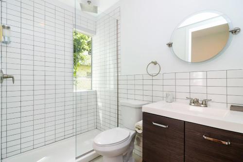 a bathroom with a toilet and a sink and a mirror at Aerie Apartments in Miami