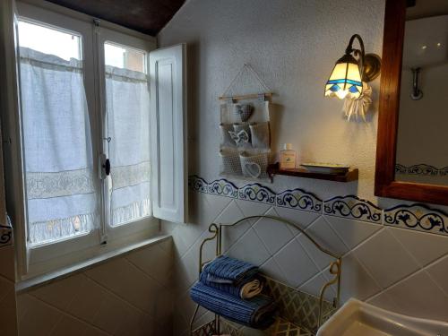 a bathroom with a sink and two windows at Casa di Corte in Scansano