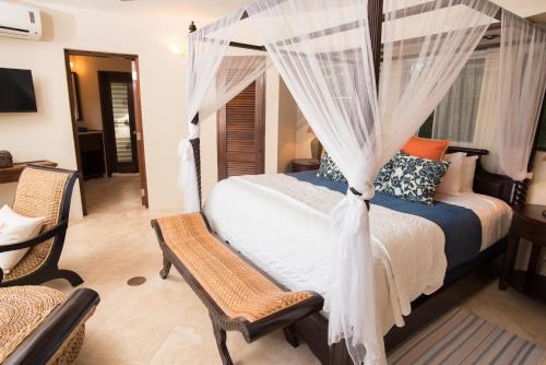 a bedroom with a bed with a mosquito net at On The Rocks Villa in Spanish Town
