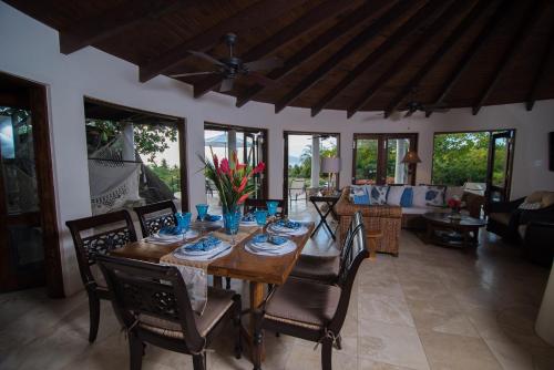 comedor con mesa de madera y sillas en On The Rocks Villa, en Spanish Town