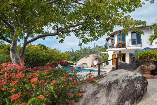 a house with a garden and flowers at On The Rocks Villa in Spanish Town