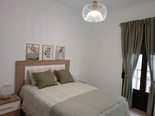 een slaapkamer met een bed en een kroonluchter bij CASA VENERA in Orgaz