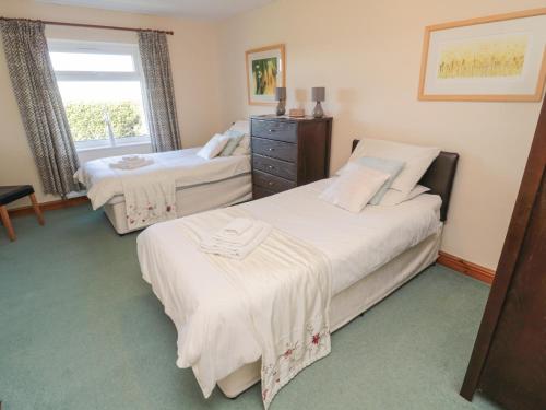 a bedroom with two beds and a window at The Retreat in Alnwick
