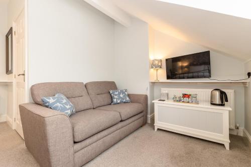 a living room with a couch and a tv at Cragwood Guest House in Keswick