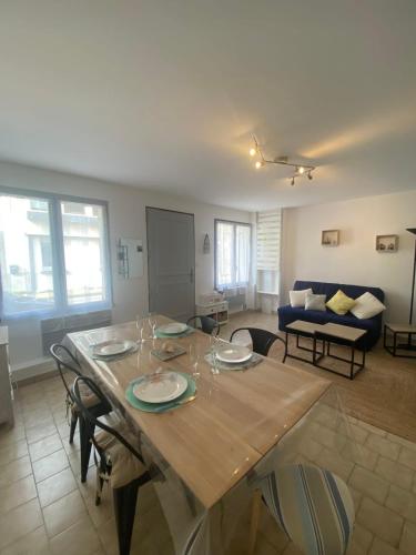 d'un salon avec une table en bois et des plaques de cuisson. dans l'établissement AD18 - L'escale Aultoise chez Hugo, à Ault