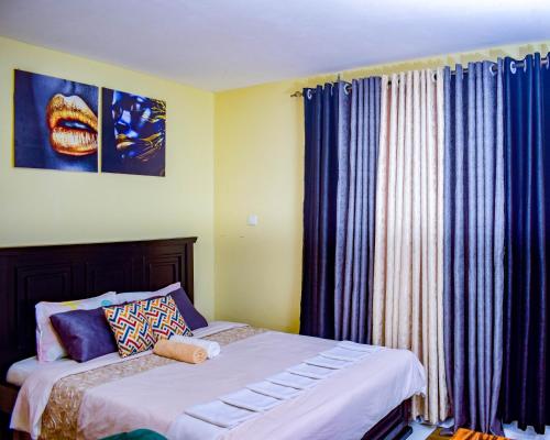 een slaapkamer met 2 bedden en een raam met gordijnen bij The Sunset Home's in Mombasa