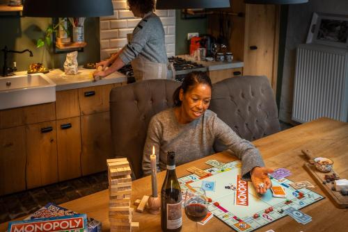 a woman sitting at a table playing a board game at Vakwerkloft in Valkenburg