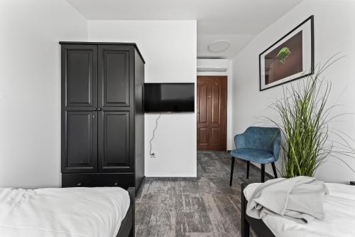 a room with two beds and a refrigerator and a chair at NOI Resort SPA - woda i las in Tęgoborze
