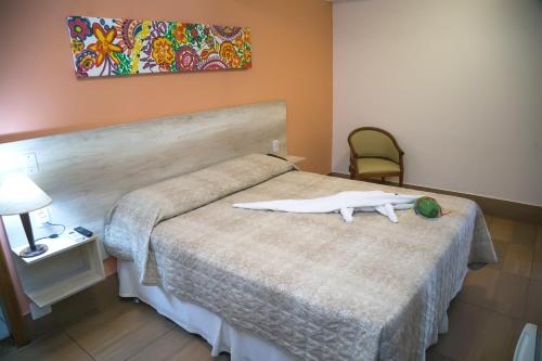 a bedroom with a bed with a white object on it at Jardim Atlântico Beach Resort in Ilhéus