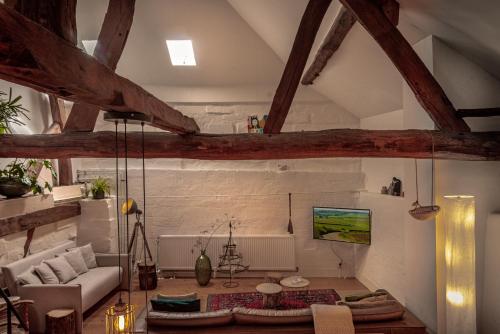 a living room with a ceiling with wooden beams at Vakwerkloft in Valkenburg