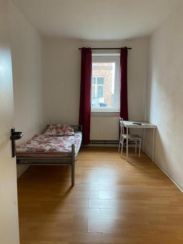 a bedroom with a bed and a table and a window at GASTEM UG in Berlin